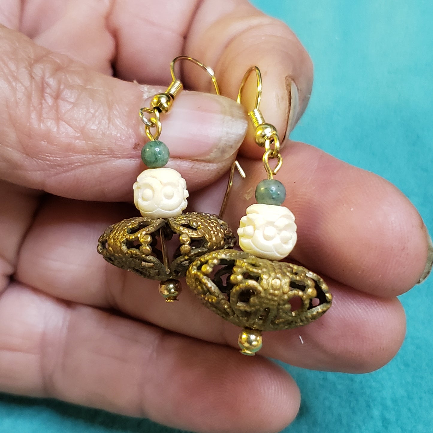 This fun little set of Dancer Earrings have been crafted from Fossil Mammoth Ivory Hand carved antique bead. They are set with 2mm Canadian Jade beads and very unique bronze filigree beads.

These are definitely a one of a kind creation. 1"×.75"