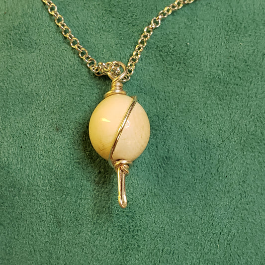 This Fossil Ivory Bead was crafted in the mid 1950 by an unknown artist in Alaska. It is wire wrapped in Sterling Silver and hung on a Sterling Silver 22" chain.

PS: I didn't disturb the patina on this bead. It has not been highly polished to retain the value of the antique quality.