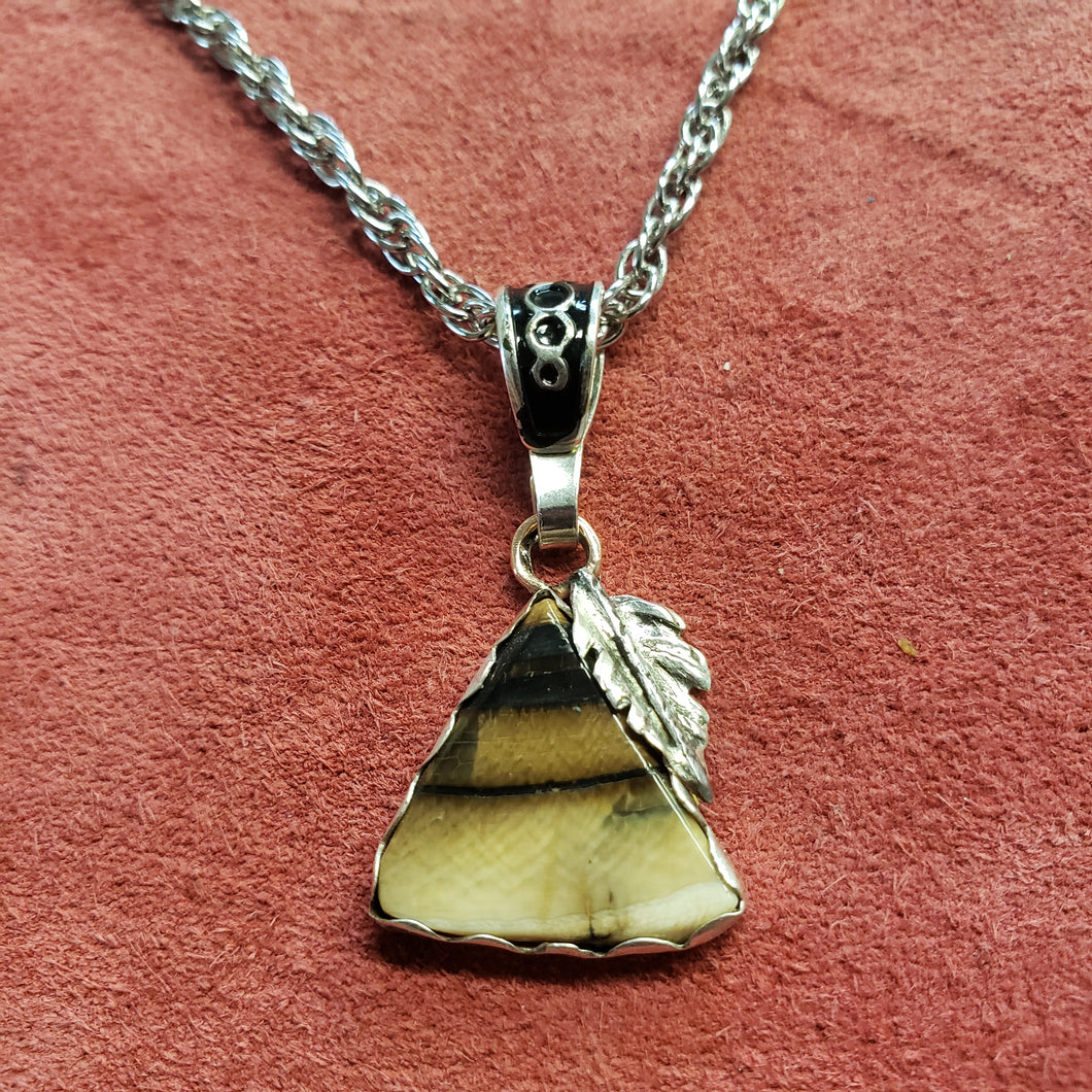 This 35,000 year old Fossil Mammoth Ivory  necklace is made from Ivory found in Alaska. It is set with a hand crafted Sterling Silver and highlighted with handcrafted Sterling Silver feather. A first for me.

This piece is hung on a stainless steel 18