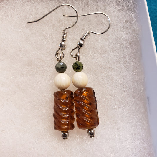 These 1" long antique gold toned glass bead earrings have been highlighted with 10,000 year old Alaskan Fossil Mammoth Ivory Beads and Canadian Jade Beads.

Hung on Hypoallergenic stainless steel earrings.