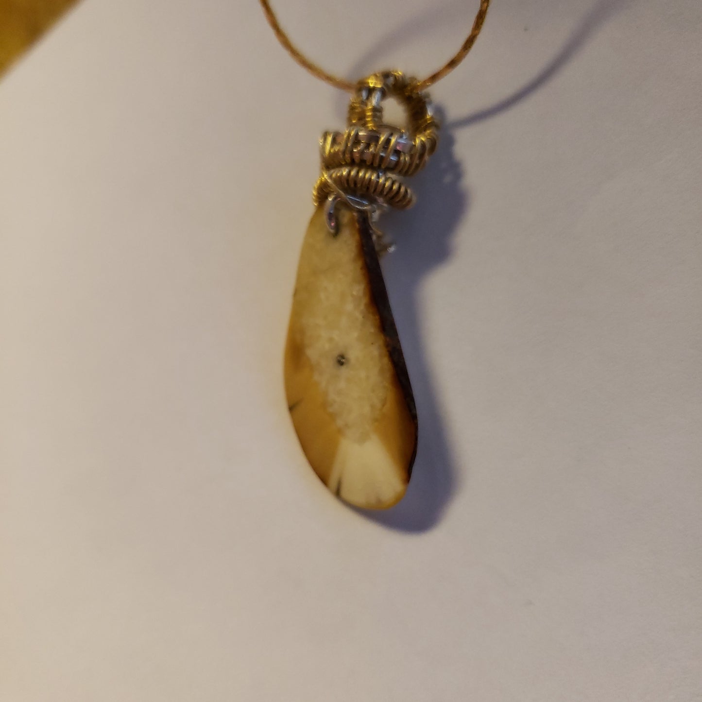 This 1.25" x .75" Fossil Walrus Ivory Pendant is many thousands of years old. It was found in Alaska on the Bering Sea coast. Hung on a 22" 18Kplt Gold Chain. Wire Wrapping by Tina of Mammoth Ivory Creations Studio 