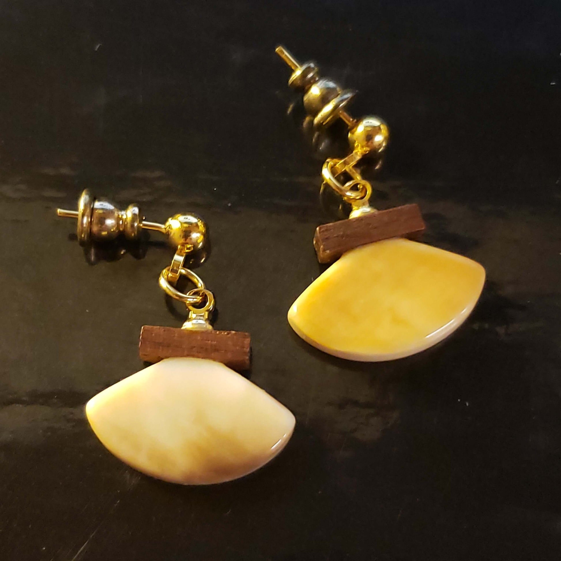 The backside of These delicate little Alaskan Ulu style earrings are handcrafted and Scrimshawed from Fossil Walrus Ivory. The brown handle is Fossil Mammoth Ivory. Artist unknown.